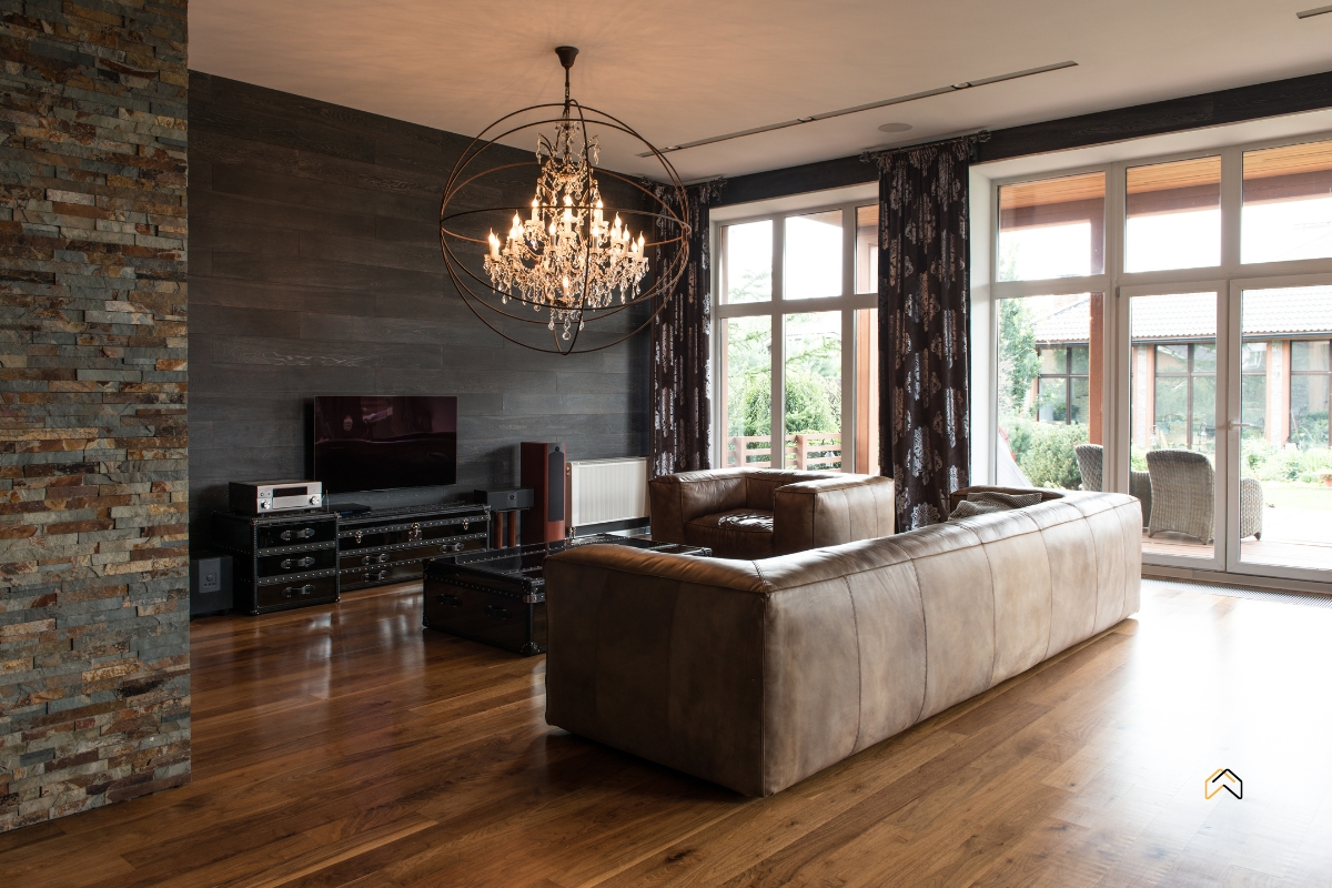 Stylowy salon z dużymi oknami, skórzaną sofą i designerskim żyrandolem